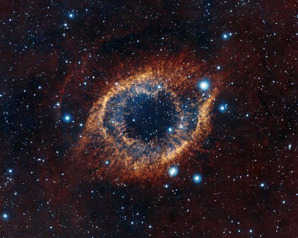 ESO's Visible and Infrared Survey Telescope for Astro<em></em>nomy (VISTA) has captured this unusual view of the Helix Nebula (NGC 7293), a planetary nebula located 700 light-years away. The coloured picture was created from images taken through Y, J and K infrared filters. While bringing to light a rich background of stars and galaxies, the telescope's infrared vision also reveals strands of cold nebular gas that are mostly obscured in visible images of the Helix. 
