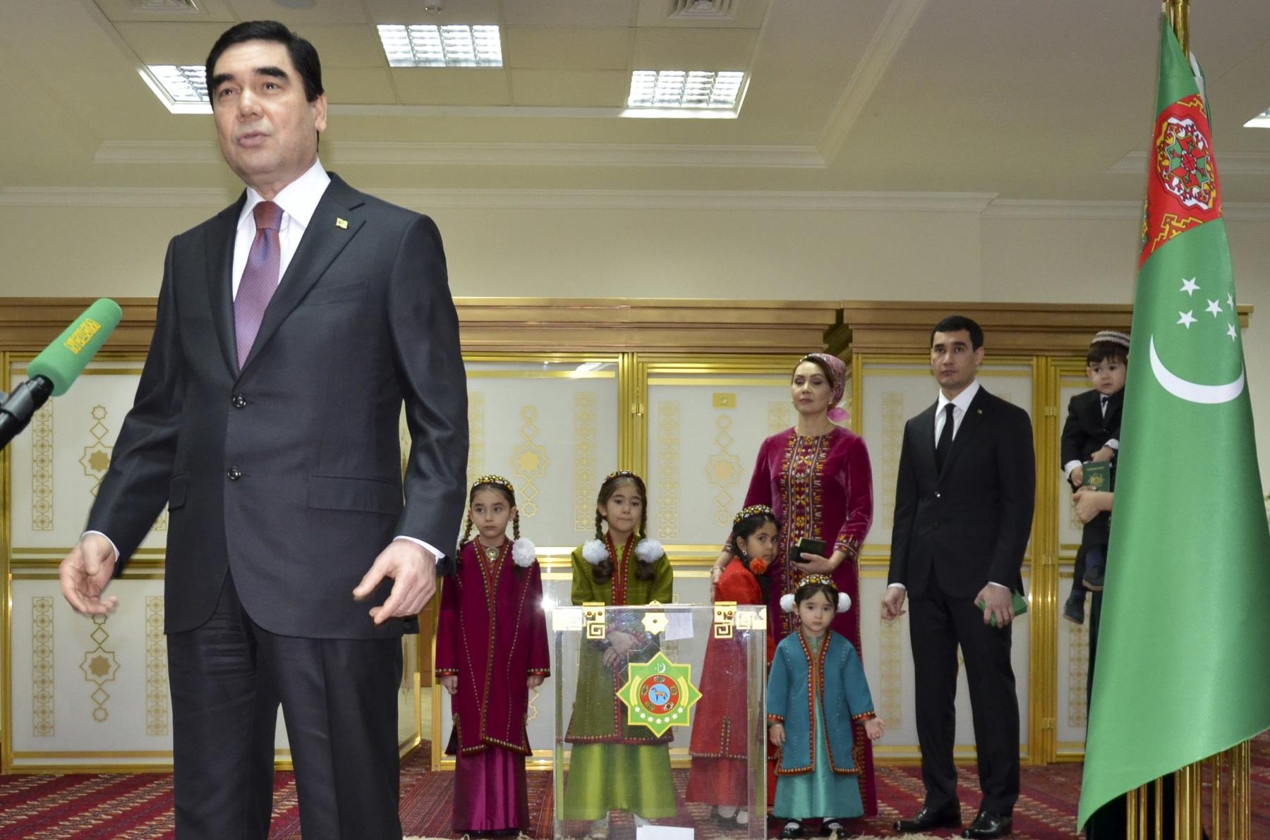 Turkmenistan President Gurbanguly Berdimuhamedov (L), speaks to journalists after casting his ballot as his son Serdar Berdymukhamedov, (2-R), with other family members look on at a polling station in Ashgabat, Turkmenistan, Feb. 12, 2017. (AP Photo)