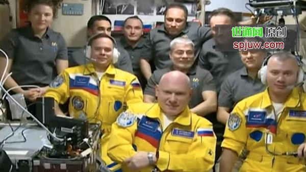 三名宇航员穿着亮黄色的连体裤抵达国际空间站