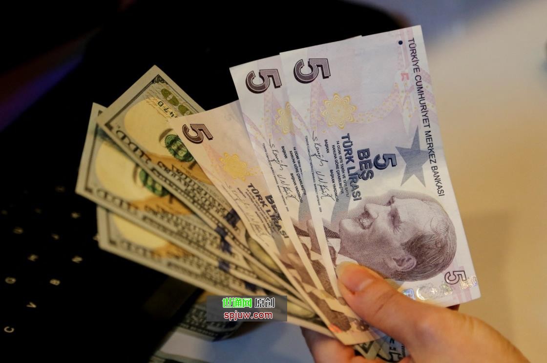 A mo<em></em>ney changer holds Turkish lira and U.S. dollar banknotes at a currency exchange office in Ankara, Turkey, Dec. 16, 2021. (Reuters Photo)