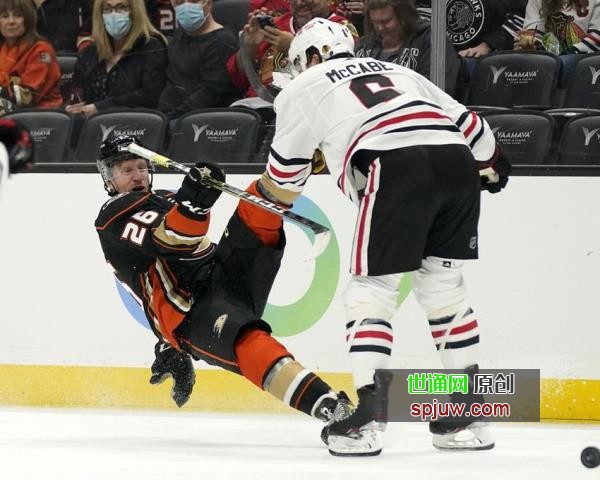 Chicago Blackhawks defenseman Jake McCabe, right, puts a hit on Anaheim Ducks center Gerry Mayhew during the second period of an NHL hockey game Wednesday, March 23, 2022, in Anaheim, Calif.