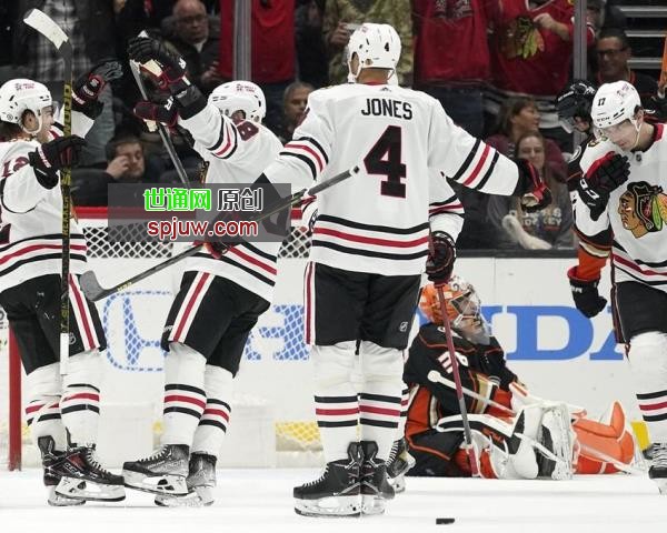 Chicago Blackhawks right wing Patrick Kane, second from left, celebrates his goal with left wing Alex DeBrincat, left, and defenseman Seth Jones, center, as Anaheim Ducks goaltender John Gibson, second from right, sits on the ice and center Dylan Strome skates over during the second period of an NHL hockey game Wednesday, March 23, 2022, in Anaheim, Calif.