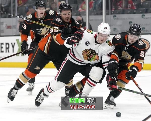 Chicago Blackhawks center Sam Lafferty, second from right, moves the puck while under pressure from Anaheim Ducks center Sam Carrick, second from left, and defenseman Jamie Drysdale, right, while right wing Buddy Robinson watches during the first period of an NHL hockey game Wednesday, March 23, 2022, in Anaheim, Calif.