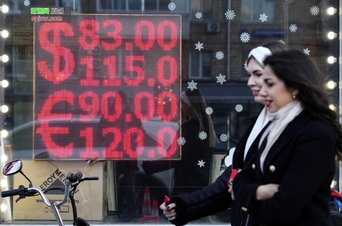 People walk past a currency exchange office screen displaying the exchange rates of U.S. dollar and euro to Russian rubles in Moscow&#039;s downtown, Russia, Feb. 28, 2022. (AP Photo)