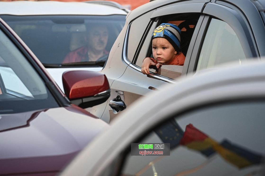 An Ukrainian child looks out of a car at the Romanian-Ukrainian border Isaccea-Orlivka on March 24, 2022. (Photo by Daniel MIHAILESCU / AFP)