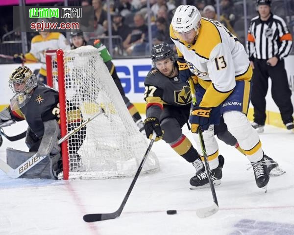 Vegas Golden Knights defenseman Shea Theodore (27) and Nashville Predators center Yakov Trenin (13) chase the puck during the first period of an NHL hockey game Thursday, March 24, 2022, in Las Vegas.