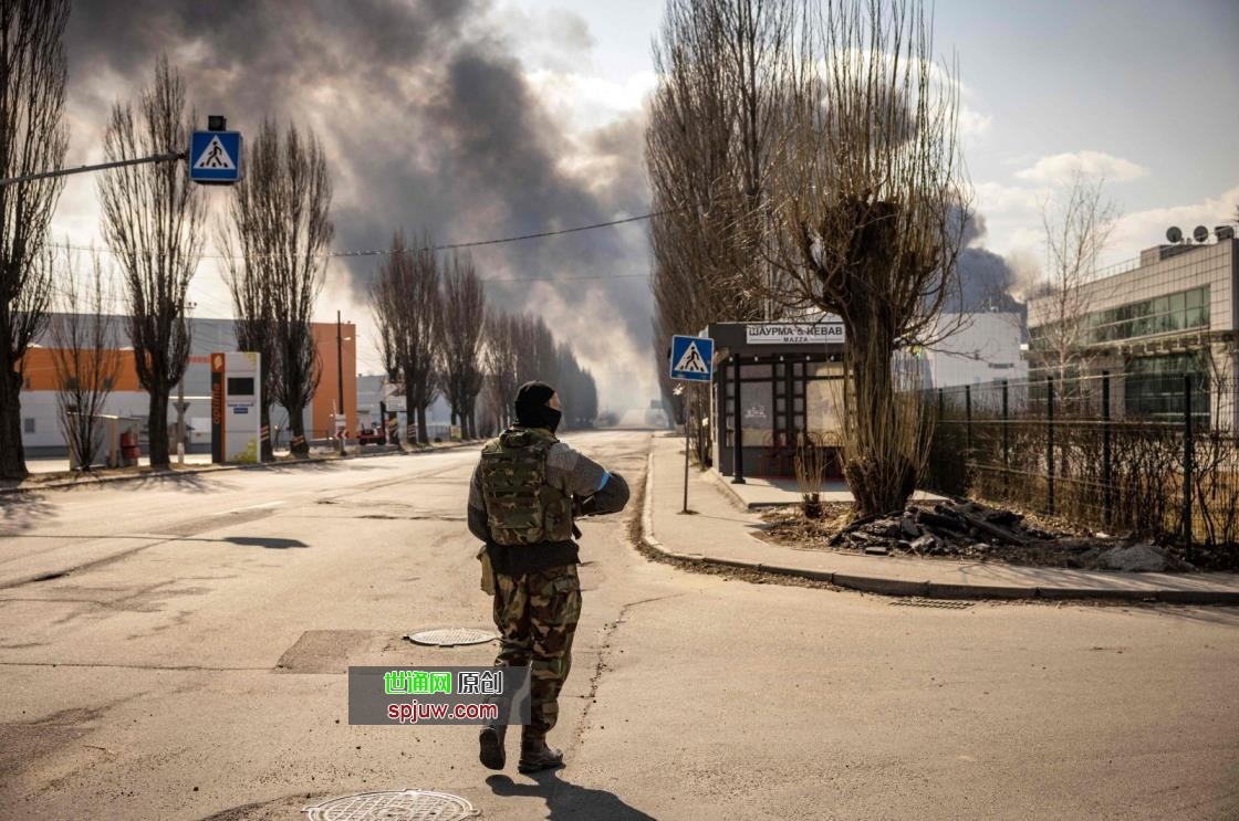 A Ukrainian soldier stands guard near a burning warehouse hit by a Russian shell in the suburbs of Kyiv, Ukraine, March 24, 2022. (AFP Photo)