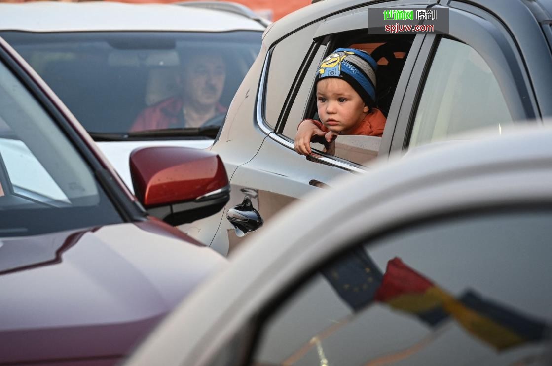An Ukrainian child looks out of a car at the Romanian-Ukrainian border Isaccea-Orlivka on March 24, 2022. (Photo by Daniel MIHAILESCU / AFP)